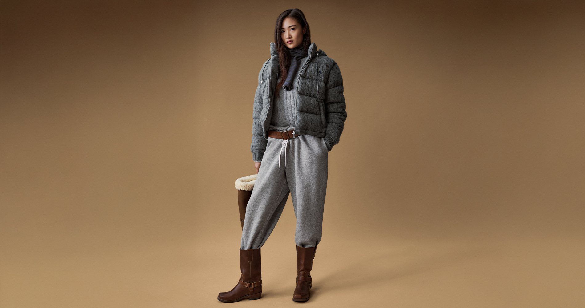 Elegantna ženska v sivem pletenem puloverju in Ralph Lauren bundi.