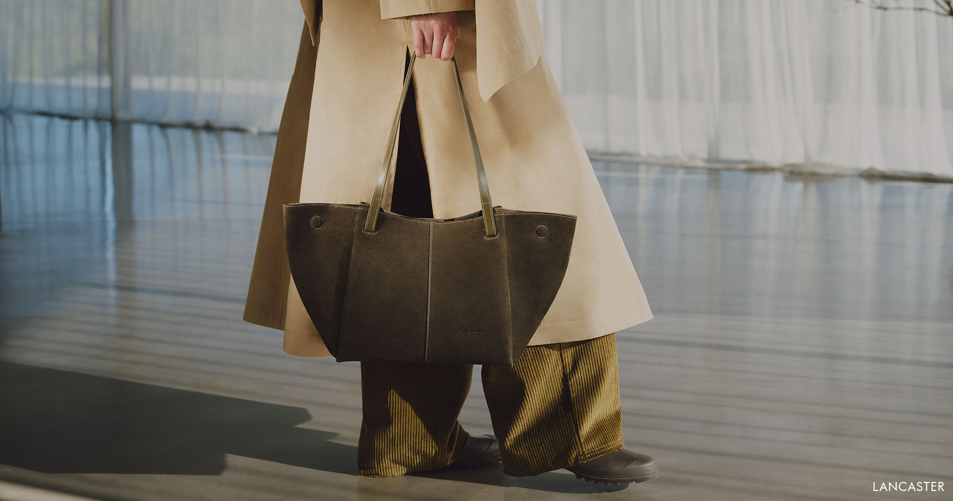 Large olive green suede tote bag styled with a light-coloured coat.